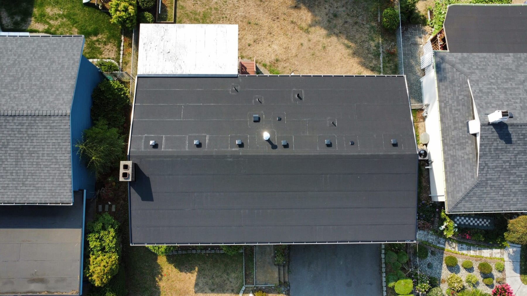 Commercial flat roof showing ponding water and tapered insulation work to restore proper drainage