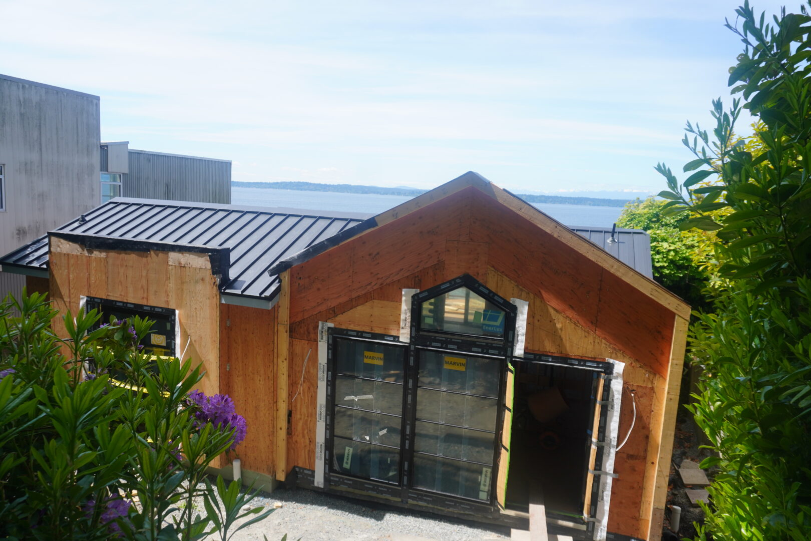 Completed metal roof installation showing finished panels, ridge cap, and flashing details on a Seattle-area home